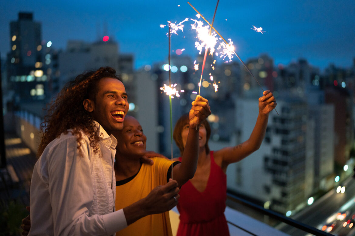 Friends celebrating New Year with sparklers at home